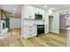 Modern kitchen featuring white cabinets, black appliances, and easy access to other living spaces at 3421 Fawn Trl, Marietta, GA 30066