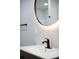 Up-close look at a bathroom vanity featuring a matte black faucet and an illuminated mirror at 3421 Fawn Trl, Marietta, GA 30066