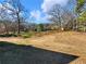 Landscaped backyard with a gentle slope and mature trees at 4248 Hog Mountain Rd, Hoschton, GA 30548