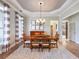 Formal dining room with hardwood floors, chandelier, and striped curtains at 4248 Hog Mountain Rd, Hoschton, GA 30548