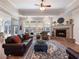 Living room with a brick fireplace, hardwood floors, and comfy seating at 4248 Hog Mountain Rd, Hoschton, GA 30548