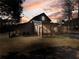Barn-style home with a screened porch at sunset at 4258 Hog Mountain Rd, Hoschton, GA 30548