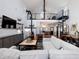 Open living area with high ceilings, loft, spiral staircase, and modern fireplace at 4258 Hog Mountain Rd, Hoschton, GA 30548