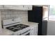 Modern kitchen with white cabinets, white appliances, and quartz countertops at 33 Country Place Ct, Alpharetta, GA 30005