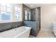 Spa-like bathroom with soaking tub, walk-in shower, and herringbone tile at 152 Palm St, Holly Springs, GA 30115
