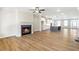 Open living room and kitchen area with hardwood floors and a cozy fireplace at 152 Palm St, Holly Springs, GA 30115