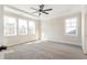 Spacious main bedroom with carpet, ceiling fan, and multiple windows at 152 Palm St, Holly Springs, GA 30115