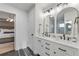 Modern bathroom with double vanity, white cabinets, and arched mirrors at 777 Forrest Nw St, Atlanta, GA 30318