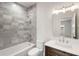 Bathroom with gray tile shower, white bathtub, toilet and modern vanity at 292 Creighton Ave, Scottdale, GA 30079