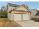 Two-story house with beige siding, brick accents and a two-car garage at 6057 Hemperly Rd, Atlanta, GA 30349
