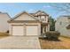 Two-story house with beige siding, brick accents, and a two-car garage at 6057 Hemperly Rd, Atlanta, GA 30349
