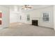 Spacious living room with neutral carpet, fireplace, and ceiling fan at 6057 Hemperly Rd, Atlanta, GA 30349