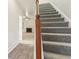 Gray carpeted staircase with wooden handrail and iron balusters at 6057 Hemperly Rd, Atlanta, GA 30349