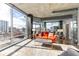 Bright living room featuring an orange leather couch and city views at 943 Peachtree Ne St # 1708, Atlanta, GA 30309