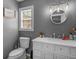 Simple bathroom with white vanity, round mirror and gray walls at 10 Toscanno Dr, Covington, GA 30014