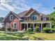 Brick two-story house with a large front porch and landscaped yard at 10 Toscanno Dr, Covington, GA 30014