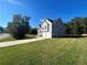 Side view of a two-story house with gray siding, large lawn, and driveway at 230 Farm St, Hiram, GA 30141