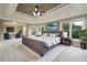 Nicely staged main bedroom featuring tray ceiling, ceiling fan, carpet flooring, and lots of natural light at 2656 Old Norcross Rd, Tucker, GA 30084