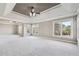 Large main bedroom featuring tray ceiling, ceiling fan, carpet flooring, and lots of natural light at 2656 Old Norcross Rd, Tucker, GA 30084