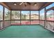 Cozy screened porch with green carpet, wood railing, and views of the backyard and neighborhood at 2656 Old Norcross Rd, Tucker, GA 30084