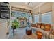 Cozy sunroom featuring a fireplace, comfortable seating, natural light, and a ceiling fan at 2540 Village Park Dr, Cumming, GA 30041