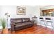 Living room with hardwood floors, brown leather sofa, and kitchen bar at 275 13Th Ne St # 1106, Atlanta, GA 30309