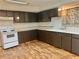 Dark brown cabinets and white appliances in a galley kitchen at 5078 Hubert Dr, Powder Springs, GA 30127