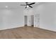 Spacious bedroom with light wood floors, white walls, ceiling fan, and multiple doorways at 2019 Arlington Nw Cir, Atlanta, GA 30318