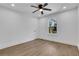 Clean and modern bedroom featuring light wood floors, white walls, ceiling fan, and a bright window view at 2019 Arlington Nw Cir, Atlanta, GA 30318