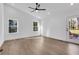 Sunlit bedroom with light wood floors, white walls, ceiling fan, and a door to a patio at 2019 Arlington Nw Cir, Atlanta, GA 30318
