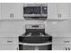 Close up of modern stainless steel oven range and microwave against a white subway tile backsplash at 2019 Arlington Nw Cir, Atlanta, GA 30318