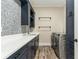 Laundry room with hexagon tile, quartz countertops, and modern washer/dryer at 7519 Waterview Cv, Douglasville, GA 30135