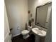 Clean and spacious half bathroom with pedestal sink and dark wood floors at 3109 Baylor Cir, Mcdonough, GA 30253