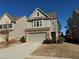 Two-story house with gray siding, brick accents, and a two-car garage at 3109 Baylor Cir, Mcdonough, GA 30253