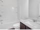 Bright bathroom featuring a shower-tub combo with white tile and a vanity with a dark wood cabinet at 4770 Marco Ln, Cumming, GA 30028