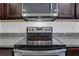 Stainless steel stove features black glass top and silver knobs at 4770 Marco Ln, Cumming, GA 30028