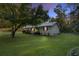 Exterior view of the house at dusk, showcasing a tree in the front yard at 52 Jennifer Ln, Carrollton, GA 30116