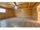 Spacious living room with wood walls and flooring, a stone fireplace, and a ceiling fan at 5520 Hearn Rd, Ellenwood, GA 30294