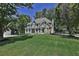 Two-story house with stone accents, front porch, and large yard at 6425 Riley Manor Way, Cumming, GA 30028