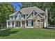 Two-story house with gray siding, stone accents, and a large yard at 6425 Riley Manor Way, Cumming, GA 30028