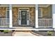 Dark stained front door with stone and white columns at 6425 Riley Manor Way, Cumming, GA 30028