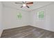 Well-lit bedroom with hardwood floors and two windows at 8658 Knox Bridge Hwy, Canton, GA 30114