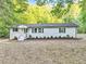 Newly renovated ranch home with white exterior, landscaping, and a large yard at 8658 Knox Bridge Hwy, Canton, GA 30114