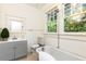 Updated bathroom with gray vanity, clawfoot tub, and large windows at 1252 Mclendon Ne Ave, Atlanta, GA 30307