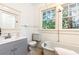 Updated bathroom with gray vanity, clawfoot tub, and large windows at 1252 Mclendon Ne Ave, Atlanta, GA 30307