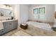 Spa-like bathroom with soaking tub, gray vanity, and tile flooring at 315 Brandenburgh Cir, Roswell, GA 30075