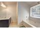 Bathroom with a bathtub, shower and double vanity with modern lighting fixtures at 4233 Creekrun Cir, Buford, GA 30519