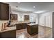 Kitchen with dark wood cabinets, granite countertops, an island, stainless steel appliances, and wood floors at 4233 Creekrun Cir, Buford, GA 30519