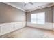 Empty room with neutral walls, white trim, carpet flooring, a ceiling fan, and a large window at 4233 Creekrun Cir, Buford, GA 30519