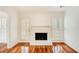 Living room featuring hardwood floors, a white fireplace, and a door and window with plantation shutters at 620 Oakledge Nw Dr, Marietta, GA 30060